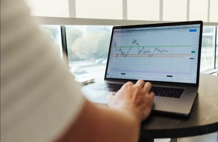 photo shows a forex trader monitoring margins on his personal laptop