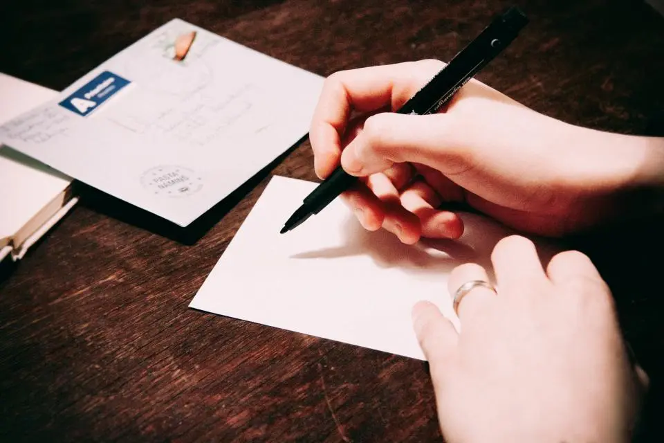 photo shows someone writing a letter